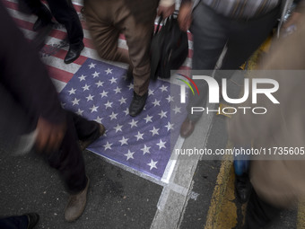 Iranian protesters walk on the U.S. flag while participating in an anti-U.S. and anti-Israel rally marking the anniversary of the U.S. embas...