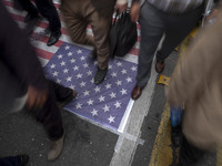 Iranian protesters walk on the U.S. flag while participating in an anti-U.S. and anti-Israel rally marking the anniversary of the U.S. embas...