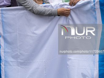 Two Iranian students prepare the U.S. flag to set on fire outside the former U.S. embassy during an anti-U.S. and anti-Israel rally marking...