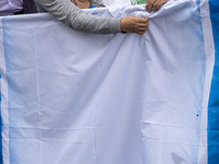 Two Iranian students prepare the U.S. flag to set on fire outside the former U.S. embassy during an anti-U.S. and anti-Israel rally marking...