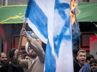 An Iranian cleric burns an Israeli flag out of the former U.S. embassy during an anti-U.S. and anti-Israel rally marking the anniversary of...