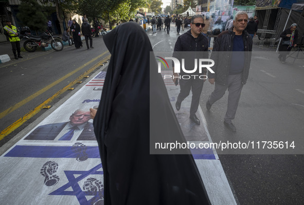 Iranian people participate in an anti-U.S. and anti-Israel rally marking the anniversary of the U.S. embassy occupation. They walk on the U....