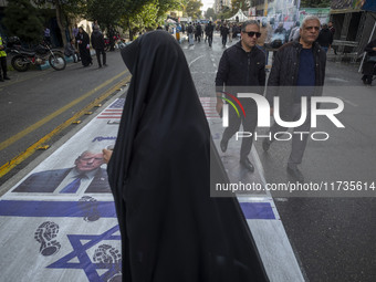 Iranian people participate in an anti-U.S. and anti-Israel rally marking the anniversary of the U.S. embassy occupation. They walk on the U....