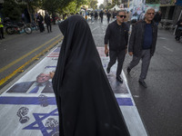 Iranian people participate in an anti-U.S. and anti-Israel rally marking the anniversary of the U.S. embassy occupation. They walk on the U....