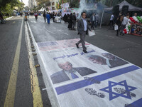 An Iranian man participates in an anti-U.S. and anti-Israel rally marking the anniversary of the U.S. embassy occupation, walking on the U.S...