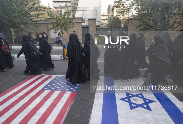 Veiled Iranian women participate in an anti-U.S. and anti-Israel rally marking the anniversary of the U.S. embassy occupation, walk on the U...