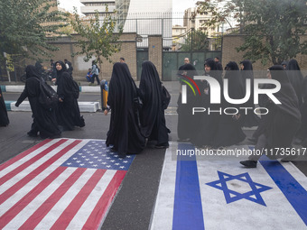 Veiled Iranian women participate in an anti-U.S. and anti-Israel rally marking the anniversary of the U.S. embassy occupation, walk on the U...