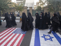 Veiled Iranian women participate in an anti-U.S. and anti-Israel rally marking the anniversary of the U.S. embassy occupation, walk on the U...