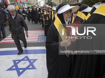 Veiled Iranian women hold portraits of the former commander of the Islamic Revolutionary Guard Corps' (IRGC) Quds Force, General Qassem Sole...