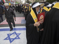 Veiled Iranian women hold portraits of the former commander of the Islamic Revolutionary Guard Corps' (IRGC) Quds Force, General Qassem Sole...