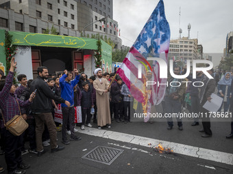 An Iranian cleric burns the U.S. flag outside the former U.S. embassy during an anti-U.S. and anti-Israel rally marking the anniversary of t...