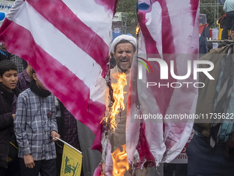 An Iranian cleric shouts anti-U.S. and anti-Israeli slogans while standing behind the burning U.S. flag outside the former U.S. embassy duri...