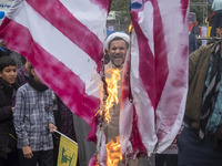 An Iranian cleric shouts anti-U.S. and anti-Israeli slogans while standing behind the burning U.S. flag outside the former U.S. embassy duri...