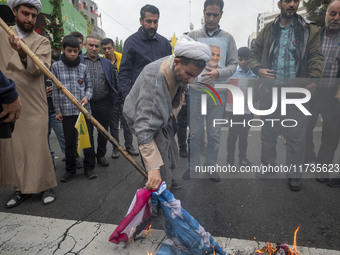 An Iranian cleric burns the U.S. flag outside the former U.S. embassy during an anti-U.S. and anti-Israel rally marking the anniversary of t...