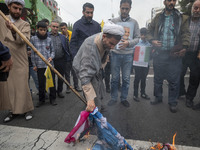 An Iranian cleric burns the U.S. flag outside the former U.S. embassy during an anti-U.S. and anti-Israel rally marking the anniversary of t...