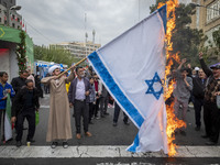 An Iranian cleric burns an Israeli flag out of the former U.S. embassy during an anti-U.S. and anti-Israel rally marking the anniversary of...