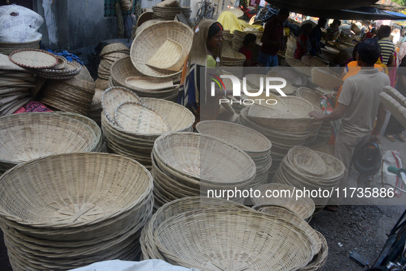 Vendors sell bamboo baskets while devotees and worshipers purchase them at a roadside market for the upcoming Chhath Puja Festival in Siligu...