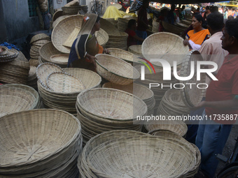 Vendors sell bamboo baskets while devotees and worshipers purchase them at a roadside market for the upcoming Chhath Puja Festival in Siligu...