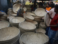 Vendors sell bamboo baskets while devotees and worshipers purchase them at a roadside market for the upcoming Chhath Puja Festival in Siligu...