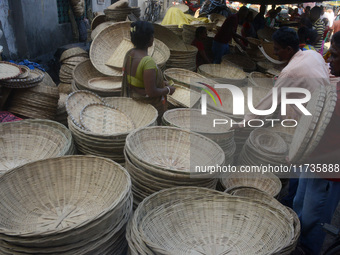 Vendors sell bamboo baskets while devotees and worshipers purchase them at a roadside market for the upcoming Chhath Puja Festival in Siligu...