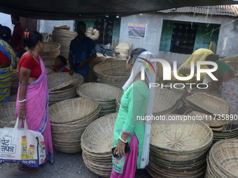 Vendors sell bamboo baskets while devotees and worshipers purchase them at a roadside market for the upcoming Chhath Puja Festival in Siligu...