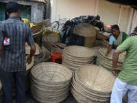 Vendors sell bamboo baskets while devotees and worshipers purchase them at a roadside market for the upcoming Chhath Puja Festival in Siligu...