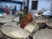 Vendors sell bamboo baskets while devotees and worshipers purchase them at a roadside market for the upcoming Chhath Puja Festival in Siligu...