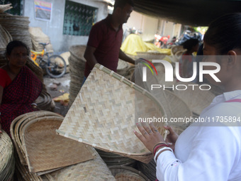 Vendors sell bamboo baskets while devotees and worshipers purchase them at a roadside market for the upcoming Chhath Puja Festival in Siligu...