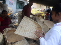 Vendors sell bamboo baskets while devotees and worshipers purchase them at a roadside market for the upcoming Chhath Puja Festival in Siligu...