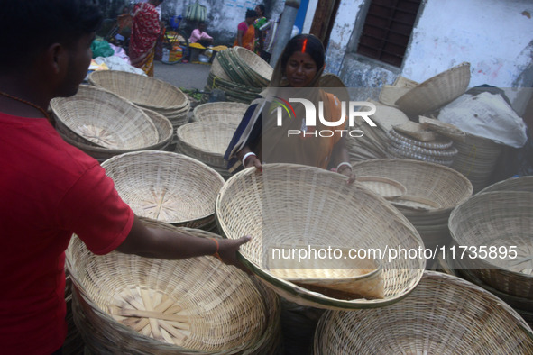 Vendors sell bamboo baskets while devotees and worshipers purchase them at a roadside market for the upcoming Chhath Puja Festival in Siligu...