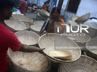 Vendors sell bamboo baskets while devotees and worshipers purchase them at a roadside market for the upcoming Chhath Puja Festival in Siligu...