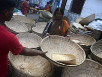 Vendors sell bamboo baskets while devotees and worshipers purchase them at a roadside market for the upcoming Chhath Puja Festival in Siligu...