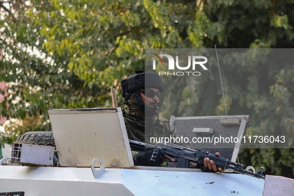 An Indian security personnel remains alert atop an armored vehicle near the site of a grenade blast at a marketplace in Srinagar, Jammu and...