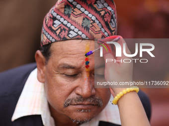 A Nepali Hindu receives a multi-colored tika on the forehead, marking the day of Bhaitika, the concluding day of Tihar, the five-day festiva...