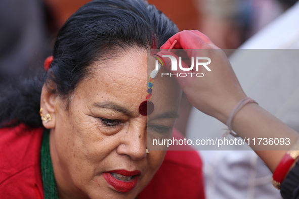 A Nepali Hindu receives a multi-colored tika on the forehead, marking the day of Bhaitika, the concluding day of Tihar, the five-day festiva...