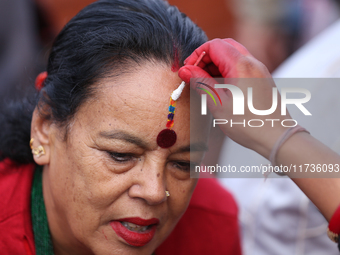 A Nepali Hindu receives a multi-colored tika on the forehead, marking the day of Bhaitika, the concluding day of Tihar, the five-day festiva...