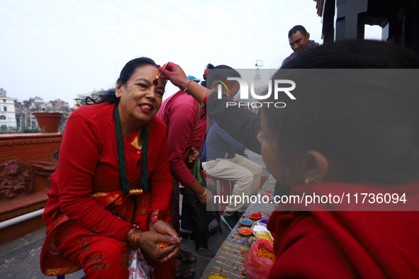 A Nepali Hindu receives a multi-colored tika on the forehead, marking the day of Bhaitika, the concluding day of Tihar, the five-day festiva...