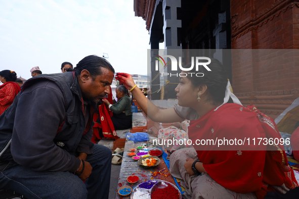 A Nepali Hindu receives a multi-colored tika on the forehead, marking the day of Bhaitika, the concluding day of Tihar, the five-day festiva...