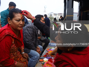 A Nepali Hindu receives a multi-colored tika on the forehead, marking the day of Bhaitika, the concluding day of Tihar, the five-day festiva...