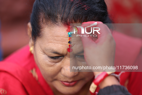 A Nepali Hindu receives a multi-colored tika on the forehead, marking the day of Bhaitika, the concluding day of Tihar, the five-day festiva...