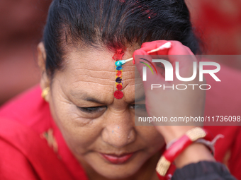 A Nepali Hindu receives a multi-colored tika on the forehead, marking the day of Bhaitika, the concluding day of Tihar, the five-day festiva...