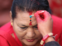 A Nepali Hindu receives a multi-colored tika on the forehead, marking the day of Bhaitika, the concluding day of Tihar, the five-day festiva...