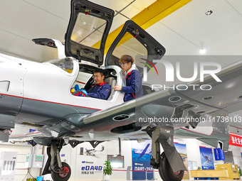 Workers adjust an aircraft at Qingdao Wanfeng Diamond Aircraft Manufacturing Co LTD in Laixi, China, on November 3, 2024. (