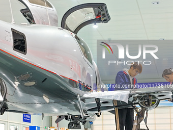 Workers assemble an aircraft at Qingdao Wanfeng Diamond Aircraft Manufacturing Co LTD in Laixi, China, on November 3, 2024. (