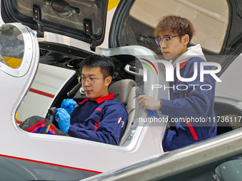 Workers adjust an aircraft at Qingdao Wanfeng Diamond Aircraft Manufacturing Co LTD in Laixi, China, on November 3, 2024. (