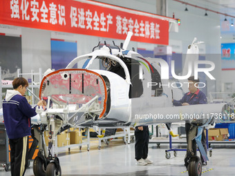 Workers assemble an aircraft at Qingdao Wanfeng Diamond Aircraft Manufacturing Co LTD in Laixi, China, on November 3, 2024. (