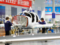 Workers assemble an aircraft at Qingdao Wanfeng Diamond Aircraft Manufacturing Co LTD in Laixi, China, on November 3, 2024. (