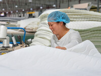 A worker makes bedding at a workshop of Wadfeng Automotive Supplies (Nantong) Co., Ltd. in Duntou town, Haian city, East China's Jiangsu pro...