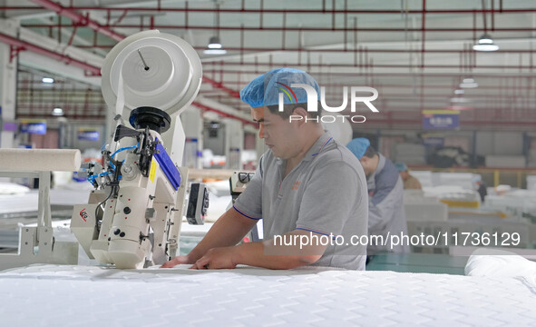 A worker makes bedding at a workshop of Wadfeng Automotive Supplies (Nantong) Co., Ltd. in Duntou town, Haian city, East China's Jiangsu pro...