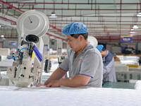 A worker makes bedding at a workshop of Wadfeng Automotive Supplies (Nantong) Co., Ltd. in Duntou town, Haian city, East China's Jiangsu pro...